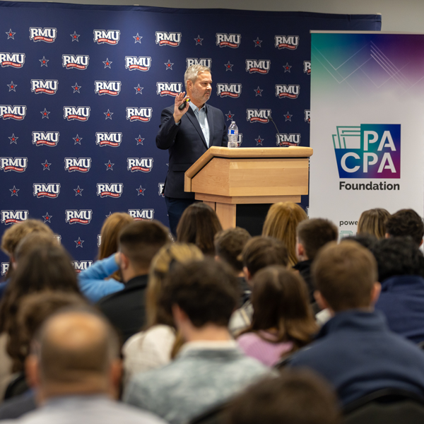 speaker at podium speaking to a room