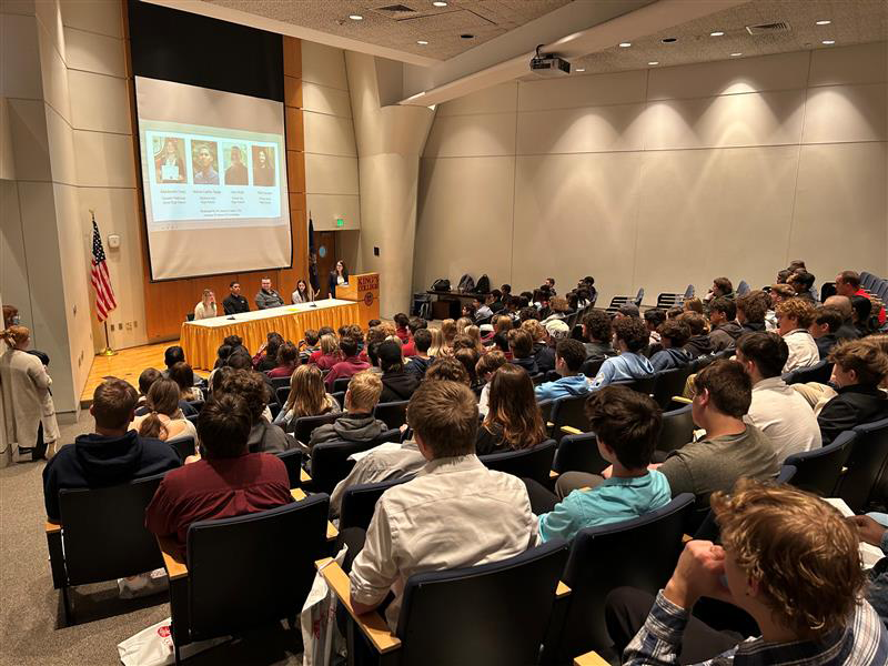 many students in an auditorium watching presentation