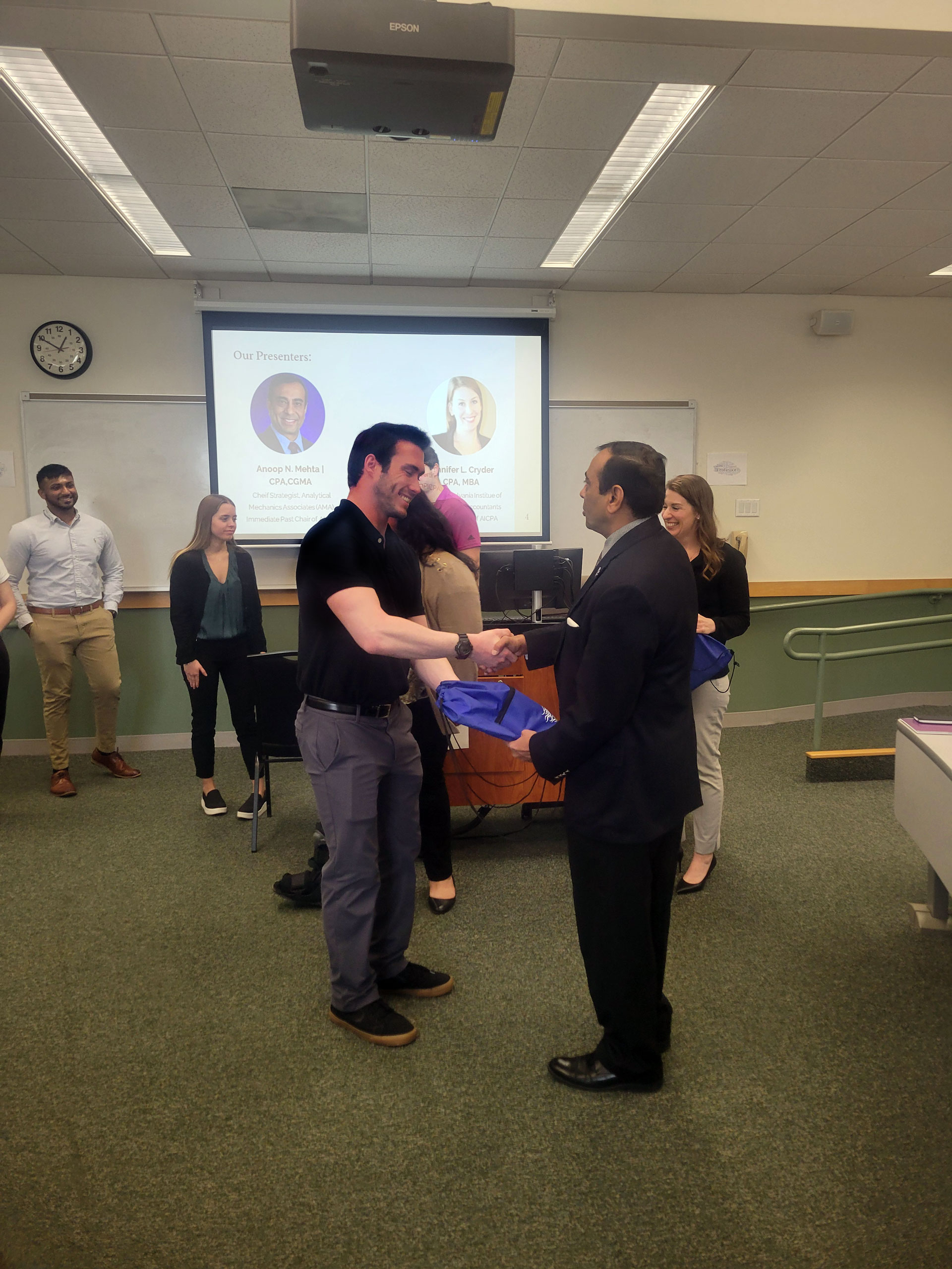 student recieving gift and shaking hand with presenter