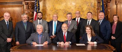 Governor Walf and CPAs around table at bill signing