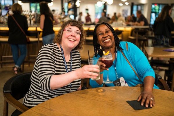 Two annual meeting reception attendees toasting