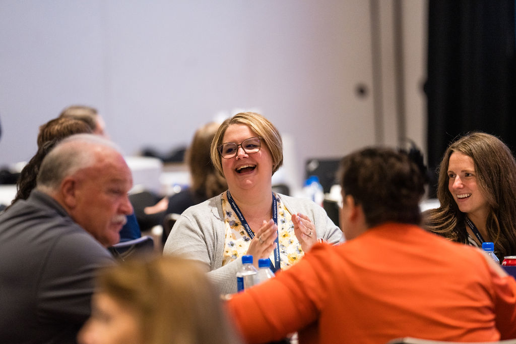 Group of PICPA members around a table, one smiling happy woman in the center
