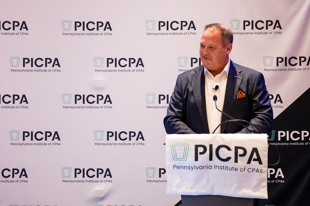 Speaker at a podium in front of PICPA backdrop