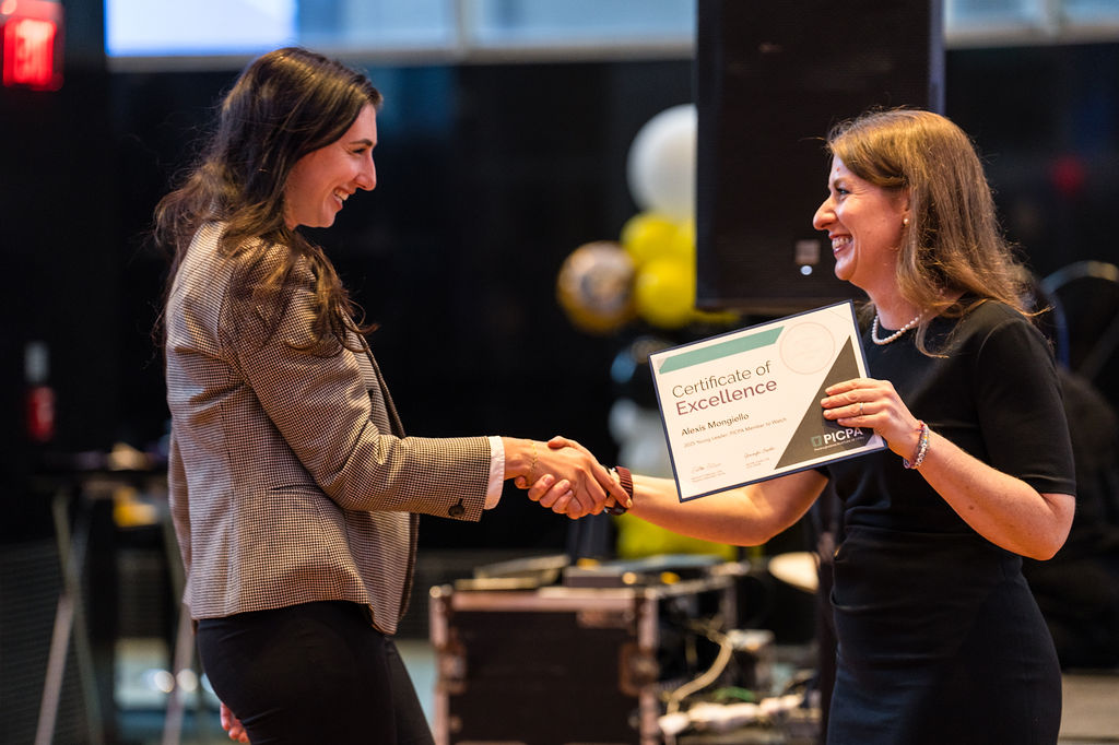 Jennifer Cryder presenting a Certificate of Excellence to a young woman CPA