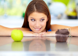 picture of girl deciding between apple and cupcake