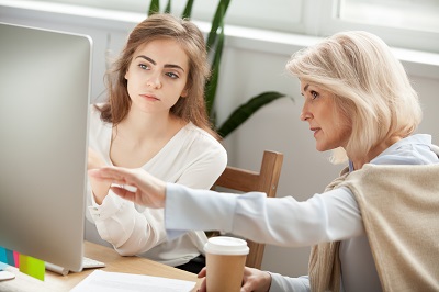 Young accountant gaining CPA Exam advice from experienced coworker.