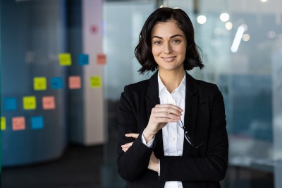 woman in business attire near glass wall of sticky notes