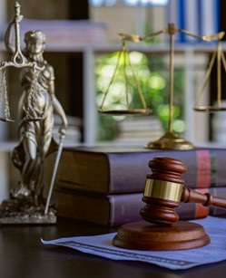 Collection of court symbols: gavel, law books, scales, statue of Justice