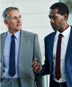 Midcareer CPA speaking with a partner while walking through the office