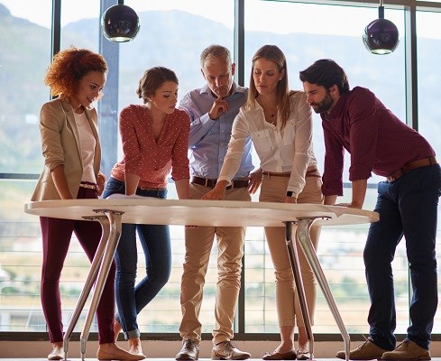 Employee-owners together discuss plans laid out on table