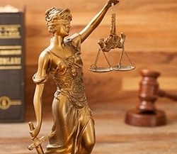Statue of "Justice" in front of gavel and law book