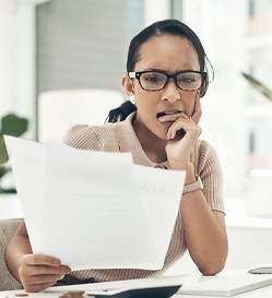 Woman seemingly anxious while reading work papers.