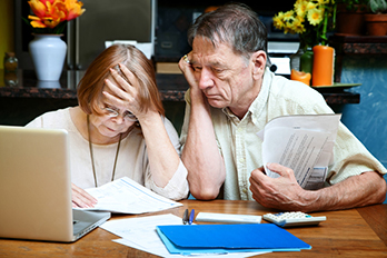 Elderly couple, reviewing papers, clearly worried