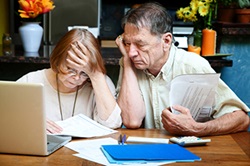 Elderly couple, reviewing papers, clearly worried