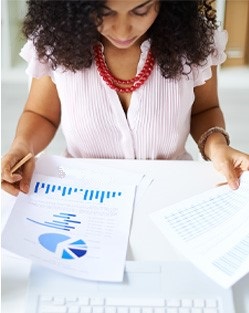 Woman reviewing pages of investment options.