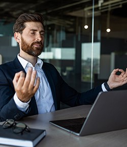 Meditating in front of a laptop computer