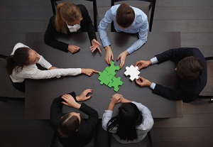 Team of six working together to solve a puzzle